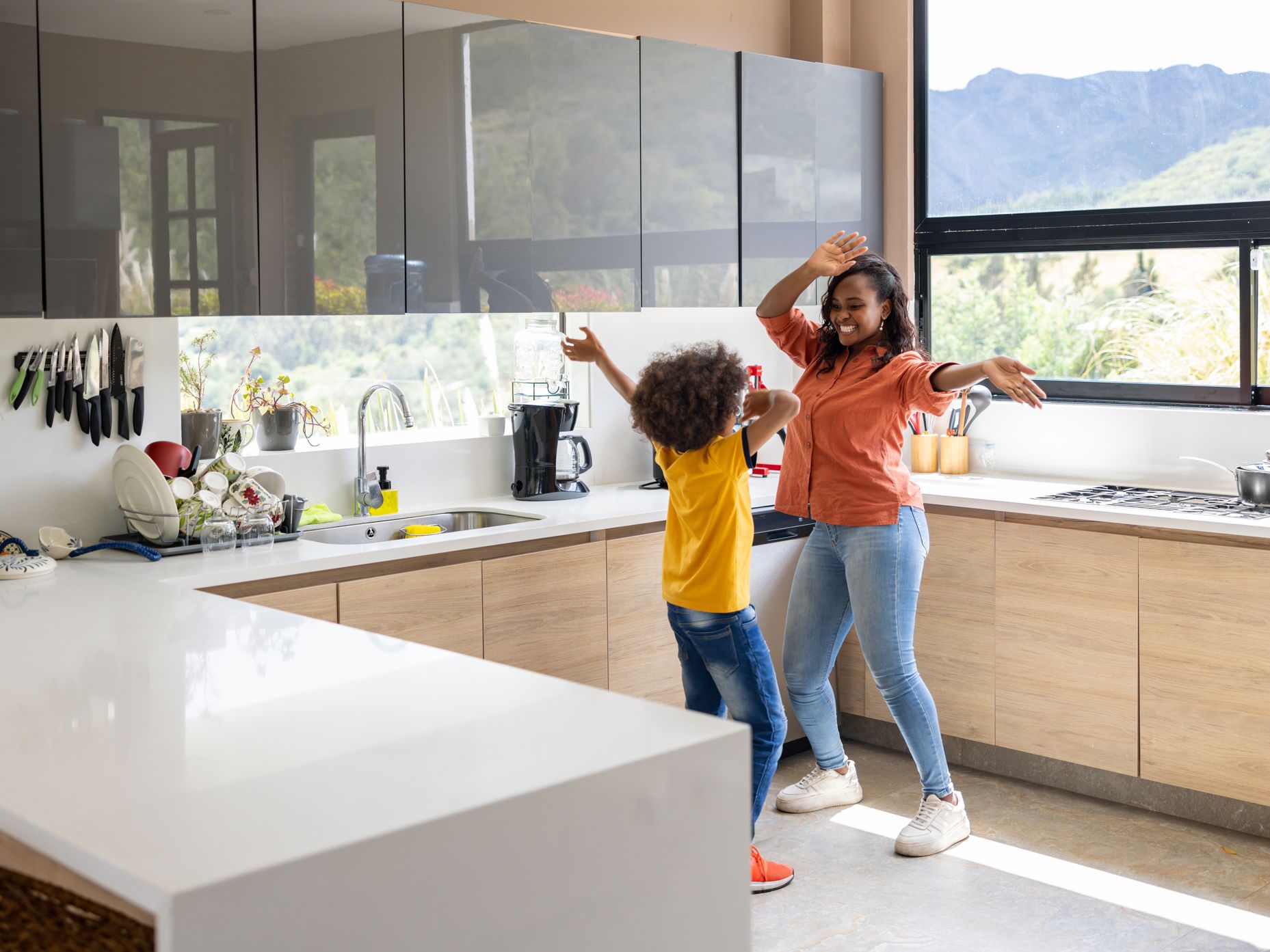 Mother and child dancing in an allergy friendly healthier kitchen